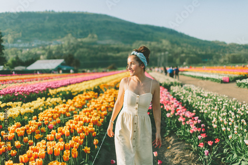 A beautiful woman walking through a field of tulips in Spring.
