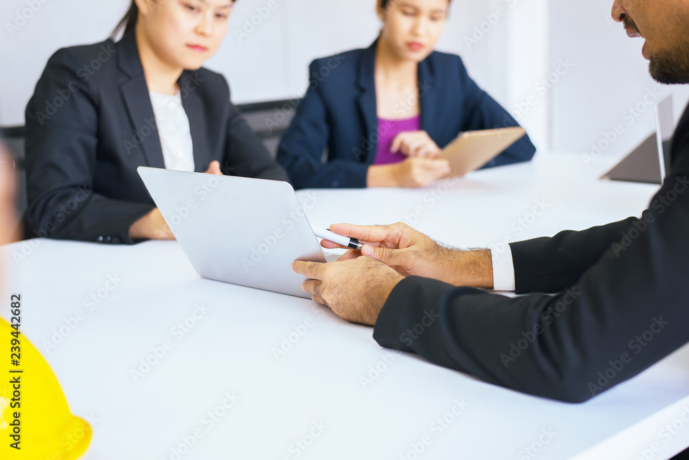 Businesspeople using labtop discussing during meeting together in conference room Businesspeople using labtop discussing during meeting together in conference room