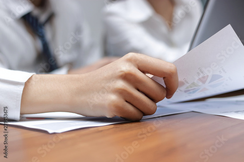 Selective focus and shallow depth of field. Paperwork or charts with business people between meeting in office.