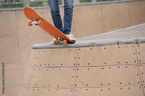 skater legs skating on ramp at skatepark