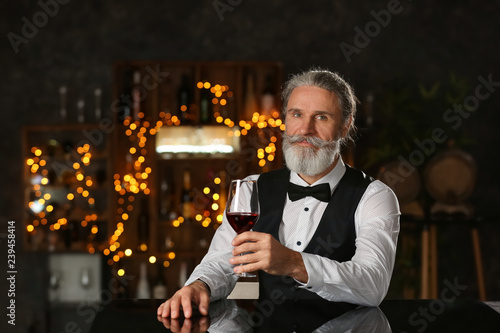 Senior man drinking wine in...