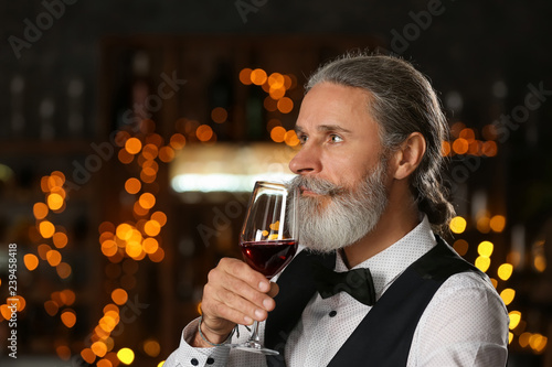 Senior man drinking wine in...