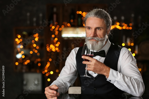 Senior man drinking wine in...
