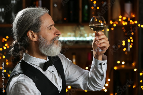 Senior man drinking wine in...