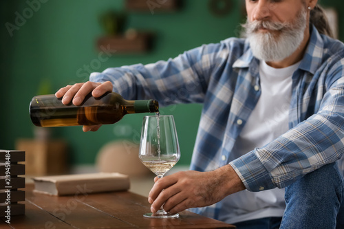 Senior man drinking wine at...