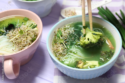 Eating of tasty Chinese soup in bowl on table