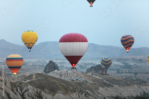 Colorful Hot Air Balloons Flying In Sky Above Rock Valley