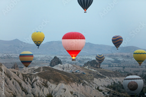 Colorful Hot Air Balloons Flying In Sky Above Rock Valley