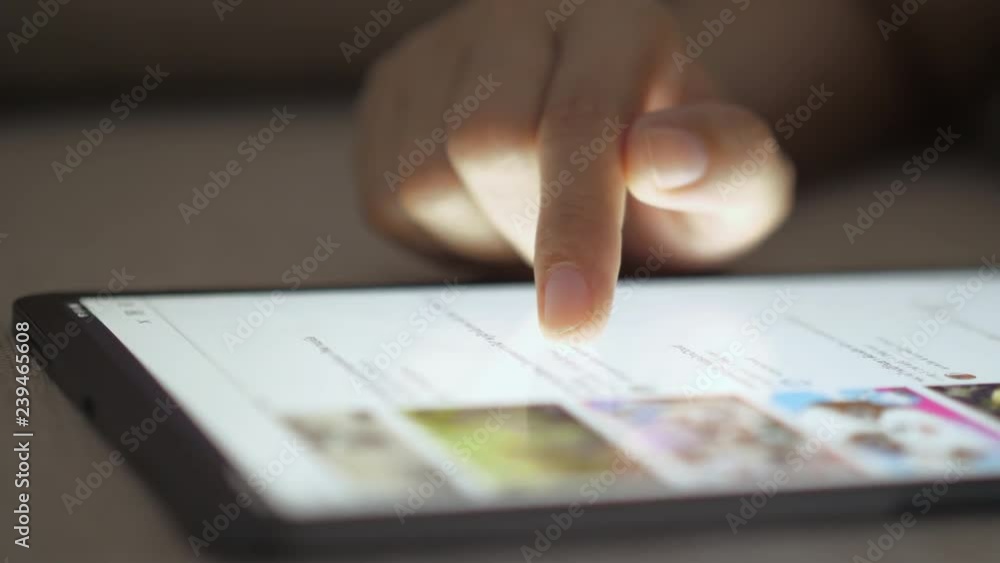 Woman's hand is touching the screen and using the tablet. Woman's hand is touching the screen and using the tablet.