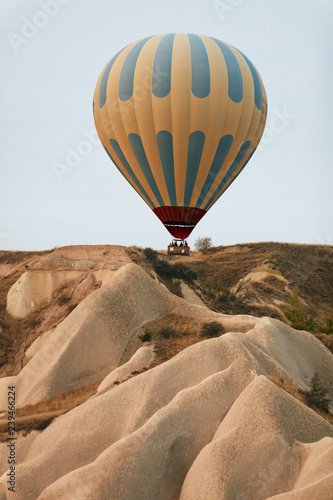 Hot Air Balloon Flying In Beautiful Nature Landscape With Rocks