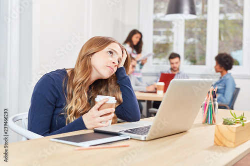 Frau sitzt nachdenklich und gestresst im Büro