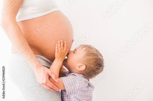 Little boy kiss the pregnant belly of mom