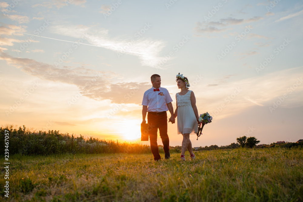 Rustic wedding couple at sunset in the field