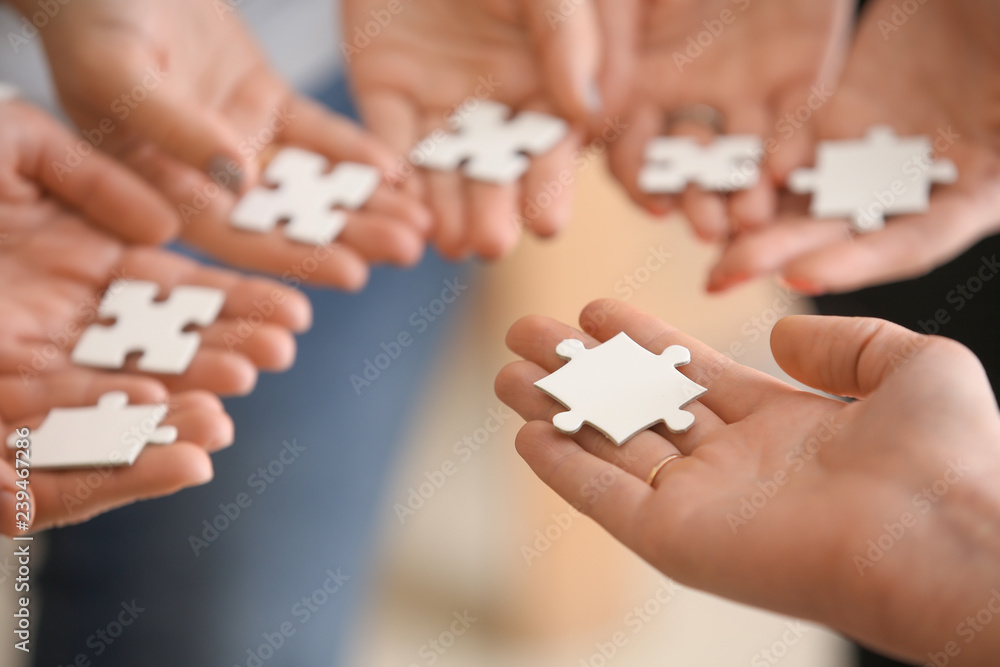 People holding pieces of jigsaw puzzle, closeup People holding pieces of jigsaw puzzle, closeup