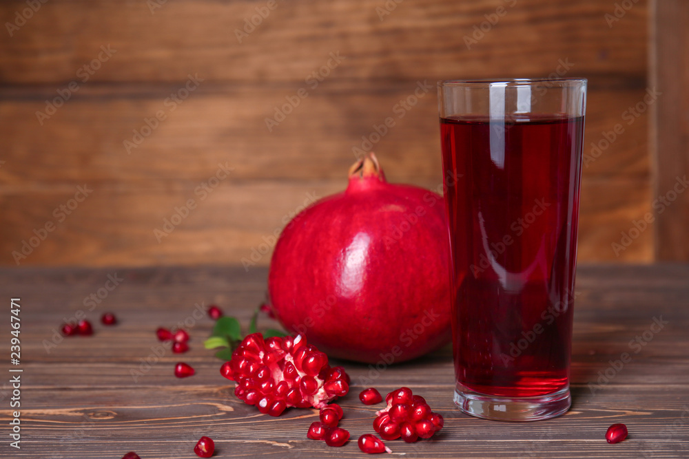 Glass of tasty pomegranate juice on wooden table Glass of tasty pomegranate juice on wooden table