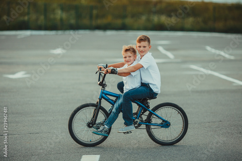 Two brothers riding together on one bicycle © oksix