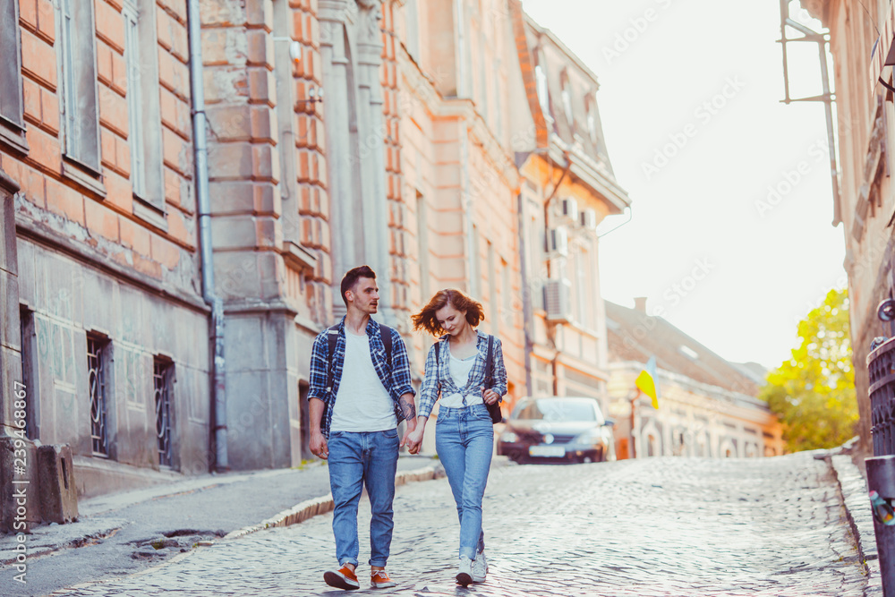 Young couple walking among historical buildings in the town