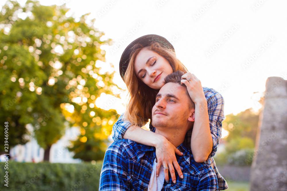 Fototapeta premium Young couple sitting on a stone wall