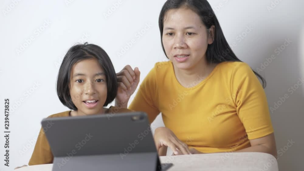 Mother and daughter enjoy watching entertainment by tablet. Mother and daughter enjoy watching entertainment by tablet.