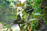 Pyramids made of round flat stones, waterfall on the background. Bali, Indonesia 