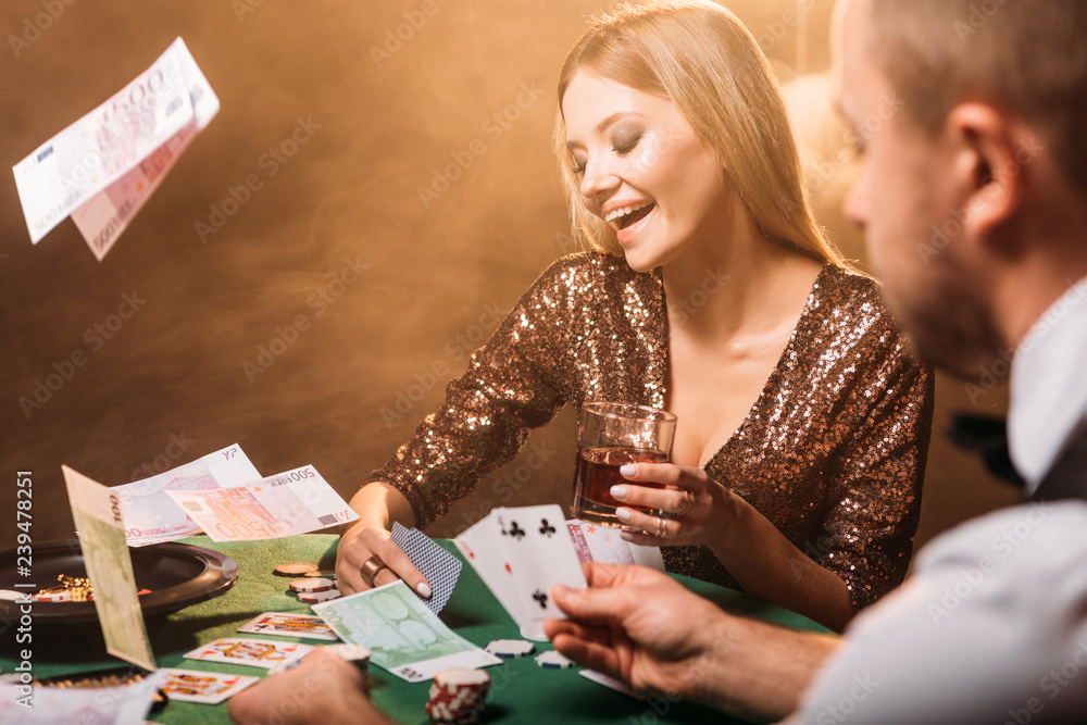 happy attractive girl playing poker with croupier at casino, euro banknotes falling on table happy attractive girl playing poker with croupier at casino, euro banknotes falling on table