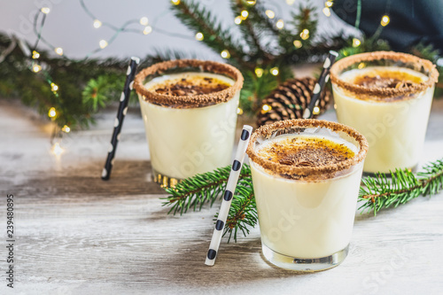 Homemade eggnog in glasses on wooden table surface
