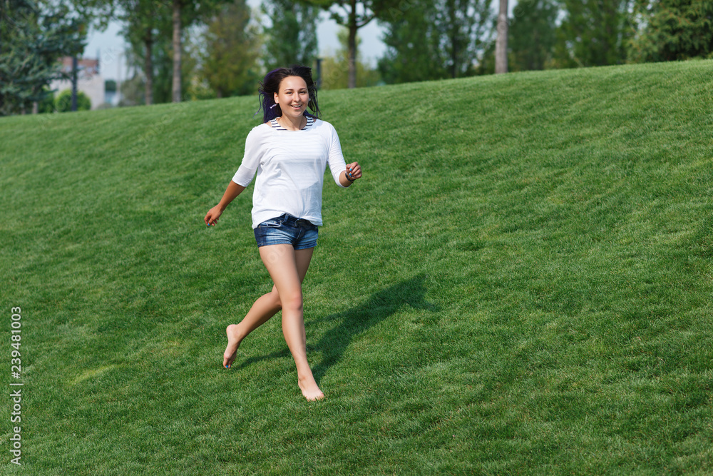 happy girl running on the lawn in the Park barefoot happy girl running on the lawn in the Park barefoot