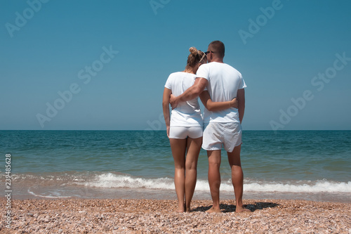 Back view of a romantic couple walking at beach during summer vacation