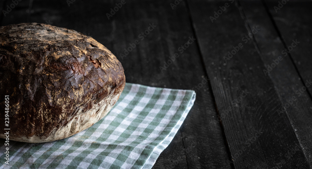 Fresh rye bread on black wooden table Fresh rye bread on black wooden table