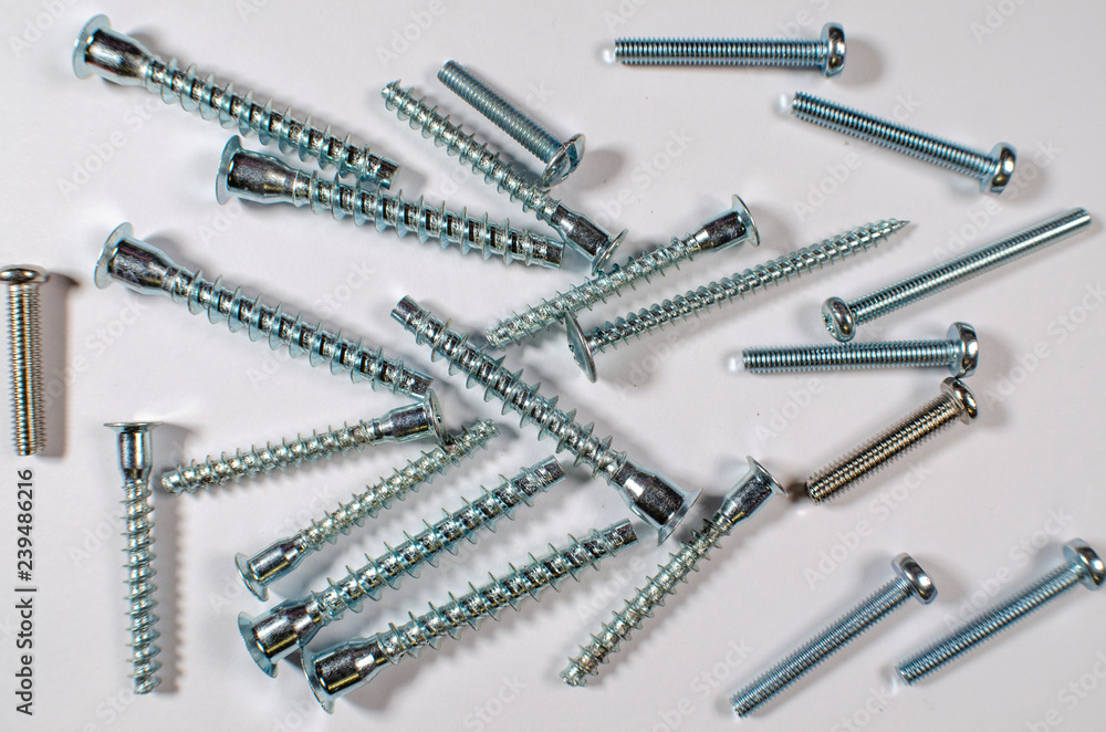White metal screws and screws on white background White metal screws and screws on white background