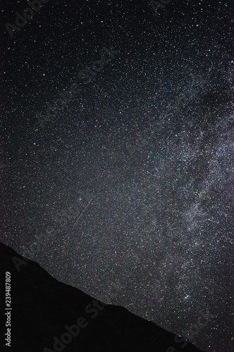 night sky full of stars over mountains, shooting star and milky way