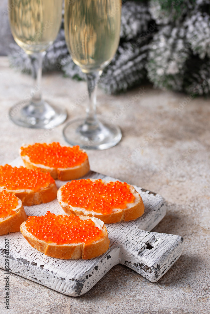 Toasts with red salmon caviar and champagne 