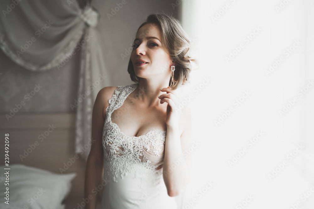 Gorgeous bride in robe posing and preparing for the wedding ceremony face in a room