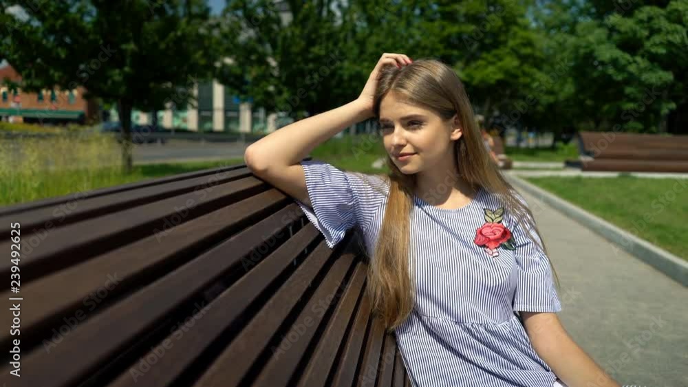 Young teenage girl relaxing on bench in city park Young teenage girl relaxing on bench in city park