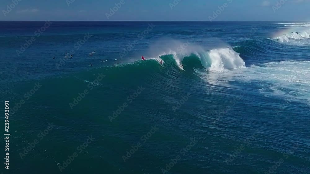 Aerial view of the surfers riding big wave on the North Shore of Oahu, Hawaii Aerial view of the surfers riding big wave on the North Shore of Oahu, Hawaii