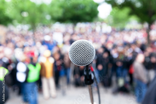 Microphone in focus against blurred protest or public demonstration © wellphoto