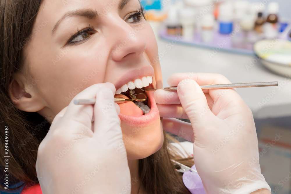 Adult young brunette woman visiting dental office. Open mouth. Dentist  hands in rubber protective gloves working with tools for patient's teeth.  Closeup. Point of view shot. Stock Photo | Adobe Stock