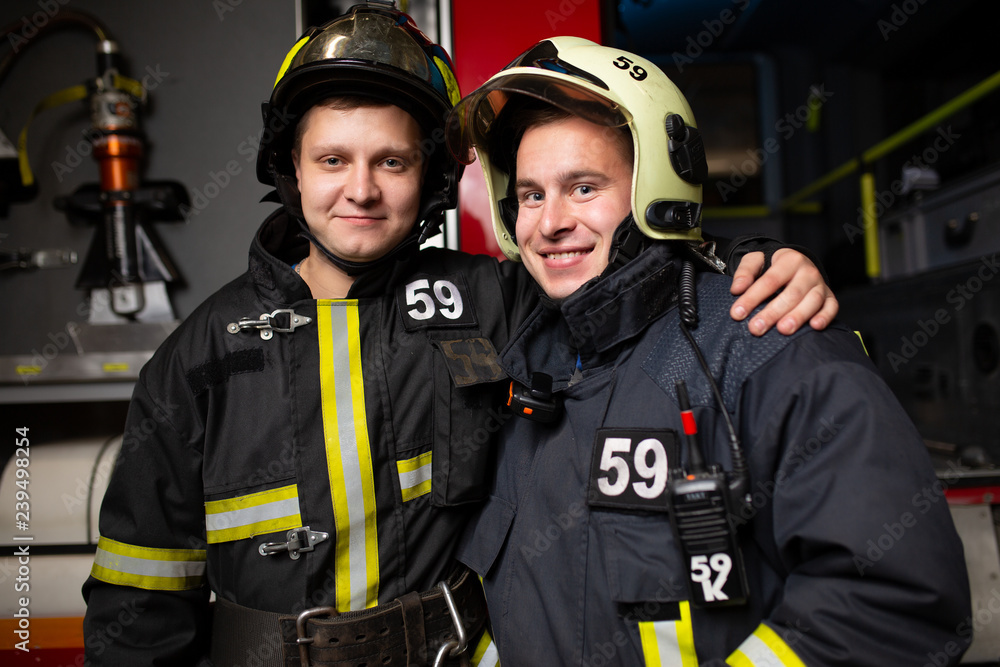 Photo of two firemen on background of fire truck Photo of two firemen on background of fire truck