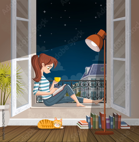 Young woman reading book in the window at night. Drinking tea and reading in ...