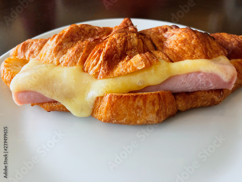 Croissant ham cheese on white dish