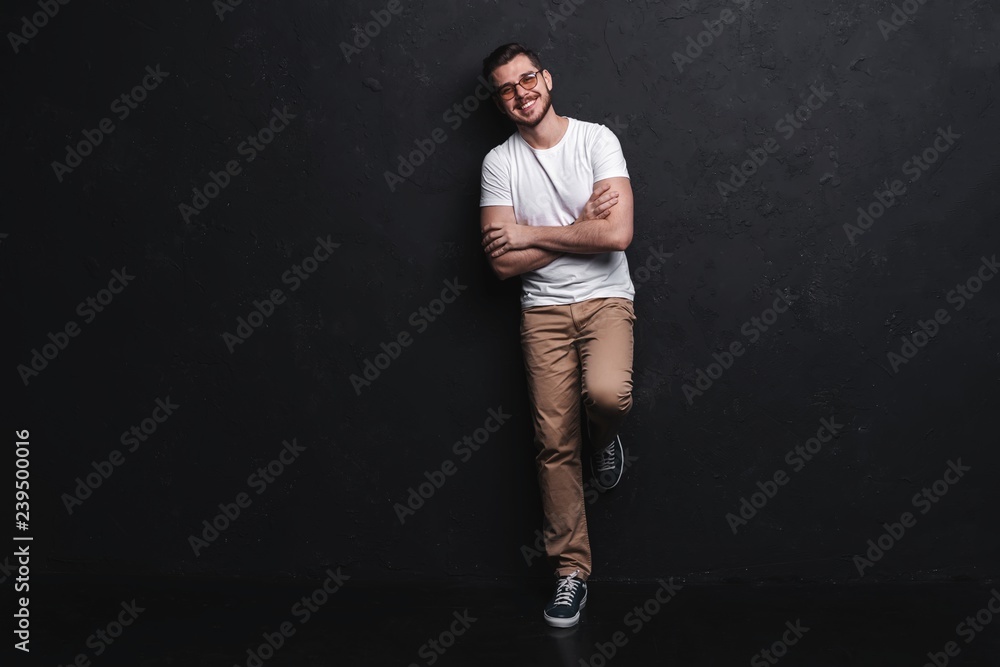 Full length portrait of happy handsome young man isolated on black background.