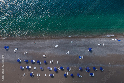Beach, view from top to bottom, blue-turquoise sea and blue umbrellas, aerial photo
