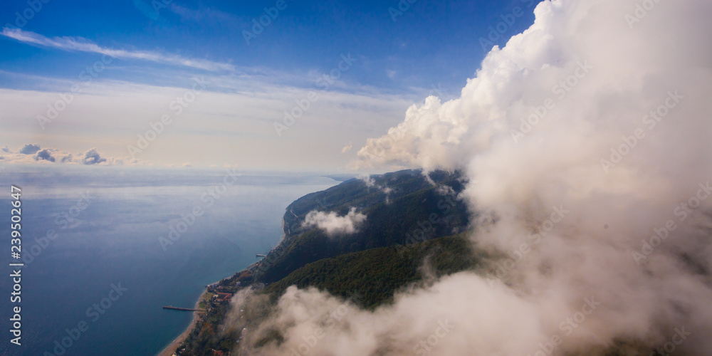 Fototapeta premium flight near the wall of clouds, free flight. Wall of clouds, blue sky and sea.