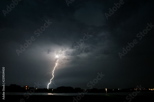 A lightning bolt strikes down from a severe thunderstorm near the river Waal in The Netherlands. Photographed during a storm chase in the Great River Area of The Netherlands.