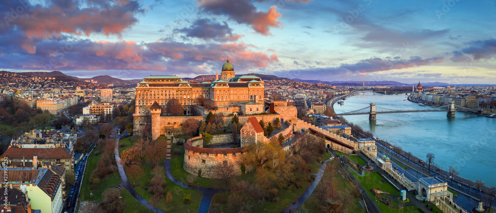 Naklejka premium Budapeszt, Węgry - Złoty wschód słońca na Zamku Królewskim w Budzie z Szechenyi Chain Bridge, Parlament i kolorowe chmury