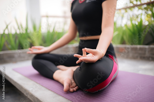 Beautiful woman doing yoga outdoors on a rooftop terrace