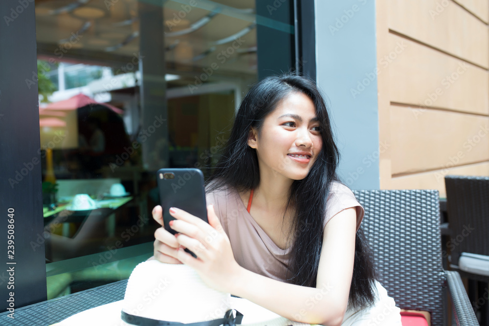 Young pretty asian woman relaxing and holding smart phone Young pretty asian woman relaxing and holding smart phone