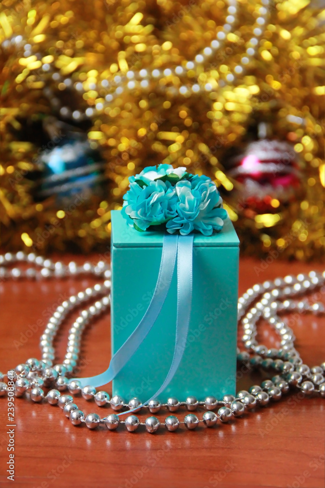 New Year's blue box with a gift on a festive Christmas background