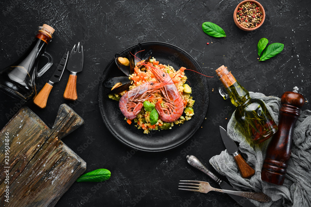 Bulgur with shrimp, mussels and vegetables. On the old background. Top view. Free space for your text.