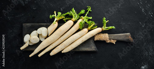 Radish Daikon on a black background. Radish. Vegetables. Top view. Free space for your text.